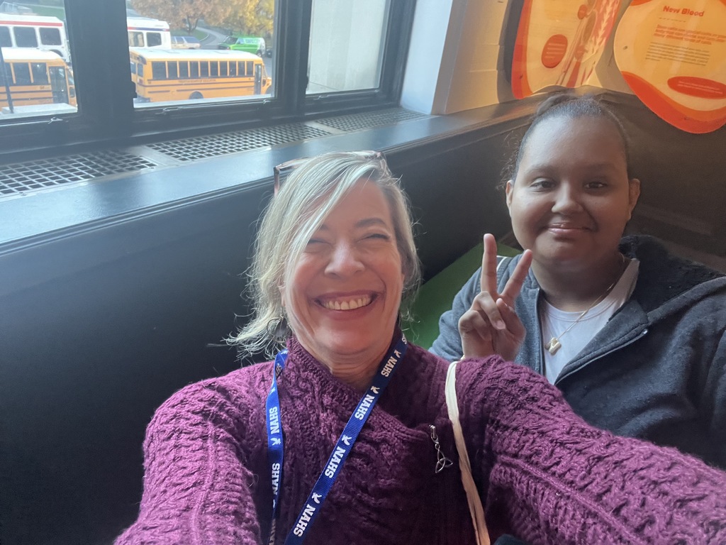A teacher and a student take a selfie at the museum together