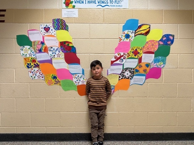A student posing with Frida Kahlo Wings.
