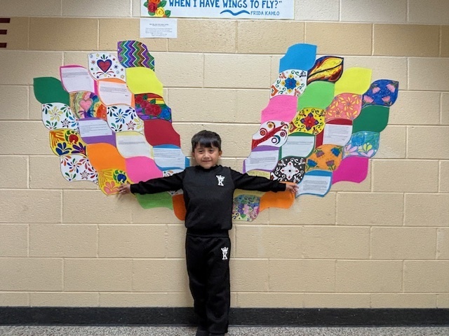 A student posing with Frida Kahlo Wings.