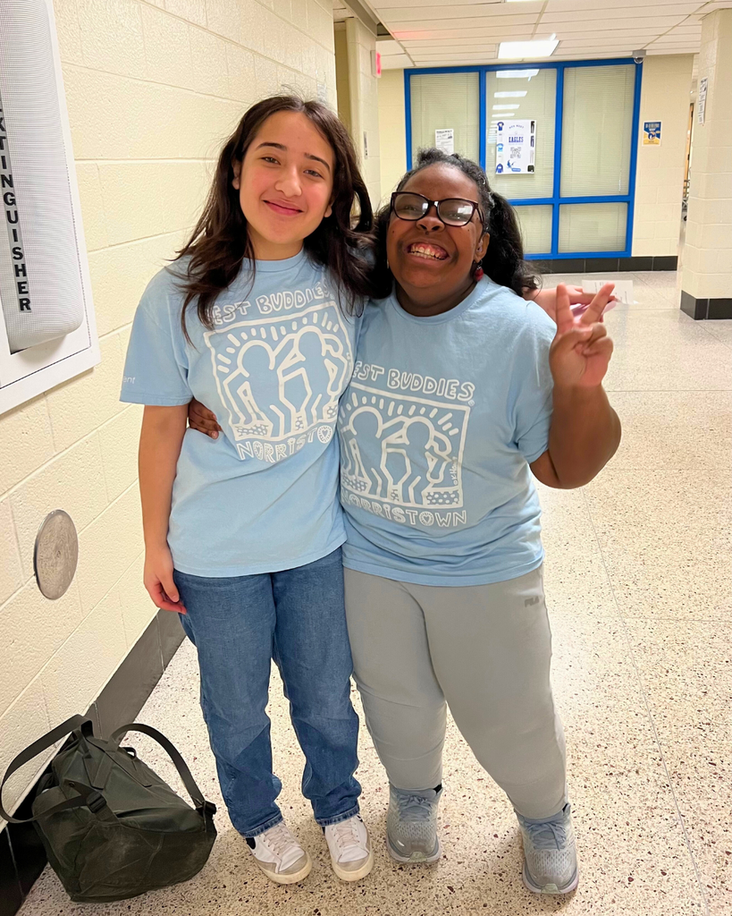 Two students pose for a photo wearing matching Best Buddies t-shirts. 