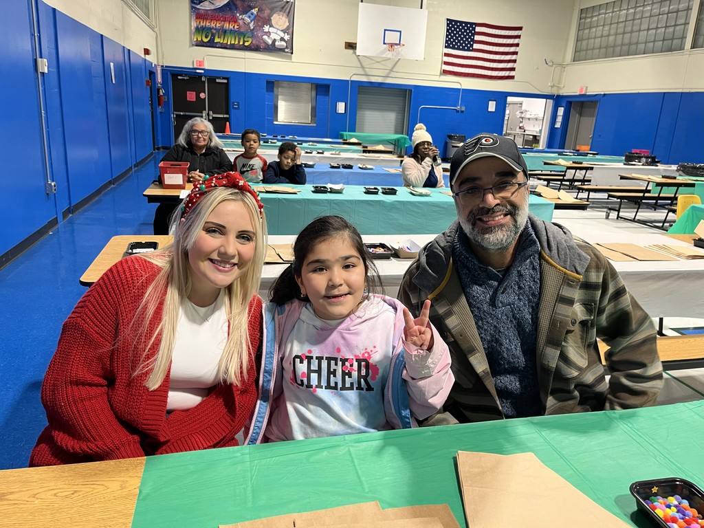 Second grade teacher and a family at the Holiday Craft Night