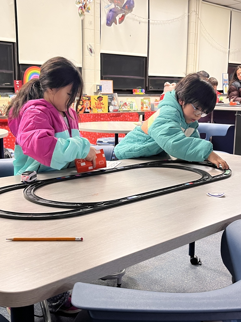 Two students playing with trains at Polar Express Night