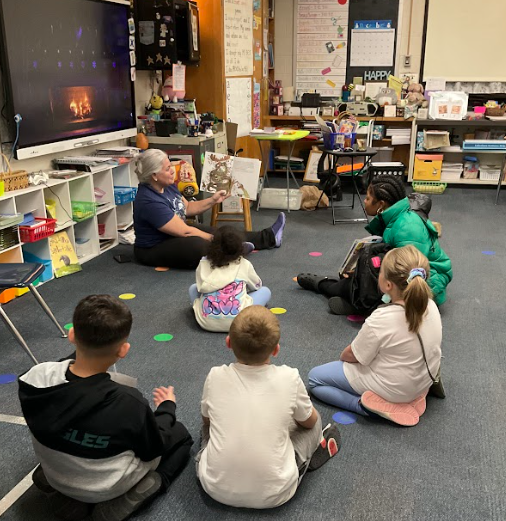 A teacher reading aloud a story at Polar Express Night