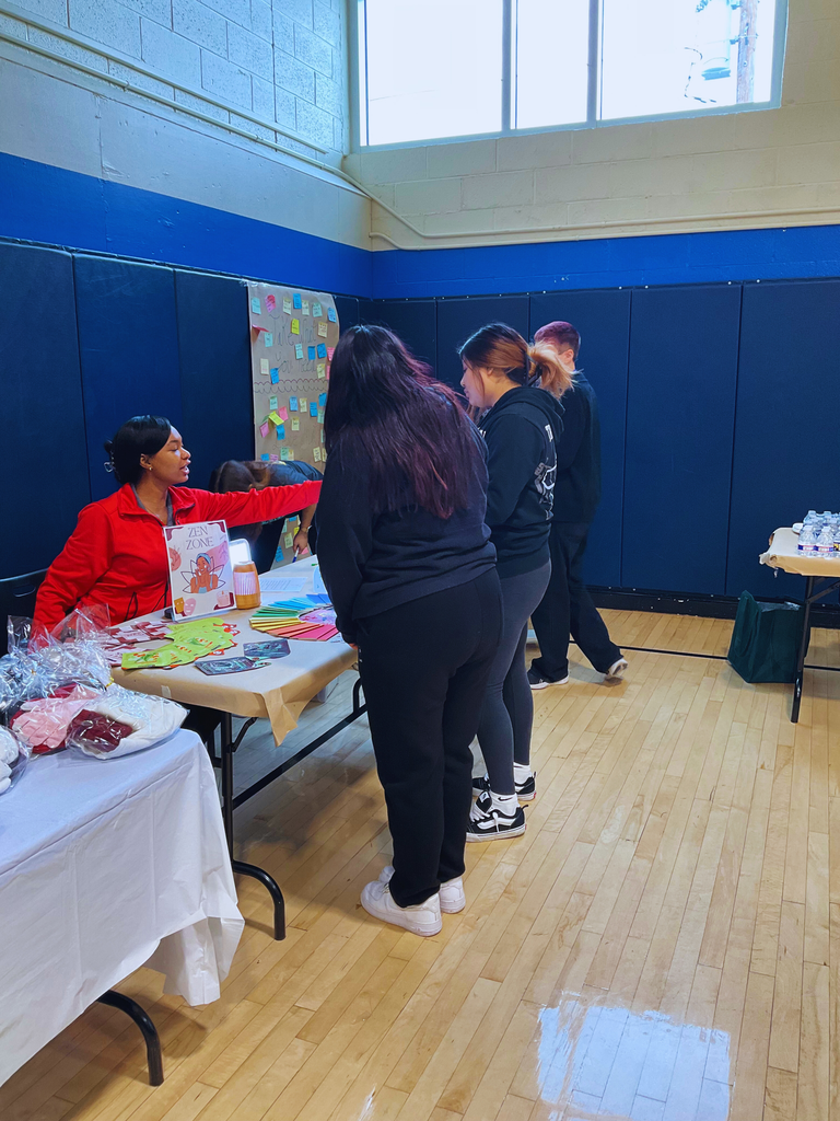 A city year coach is at a table with two students.