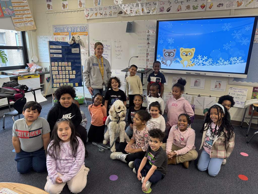 First graders pose with Nutmeg the service dog.