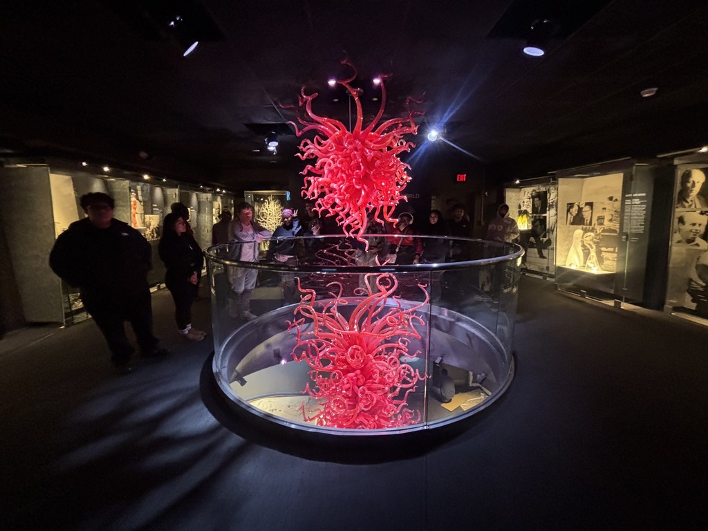 Students are in front of a sculpture. 