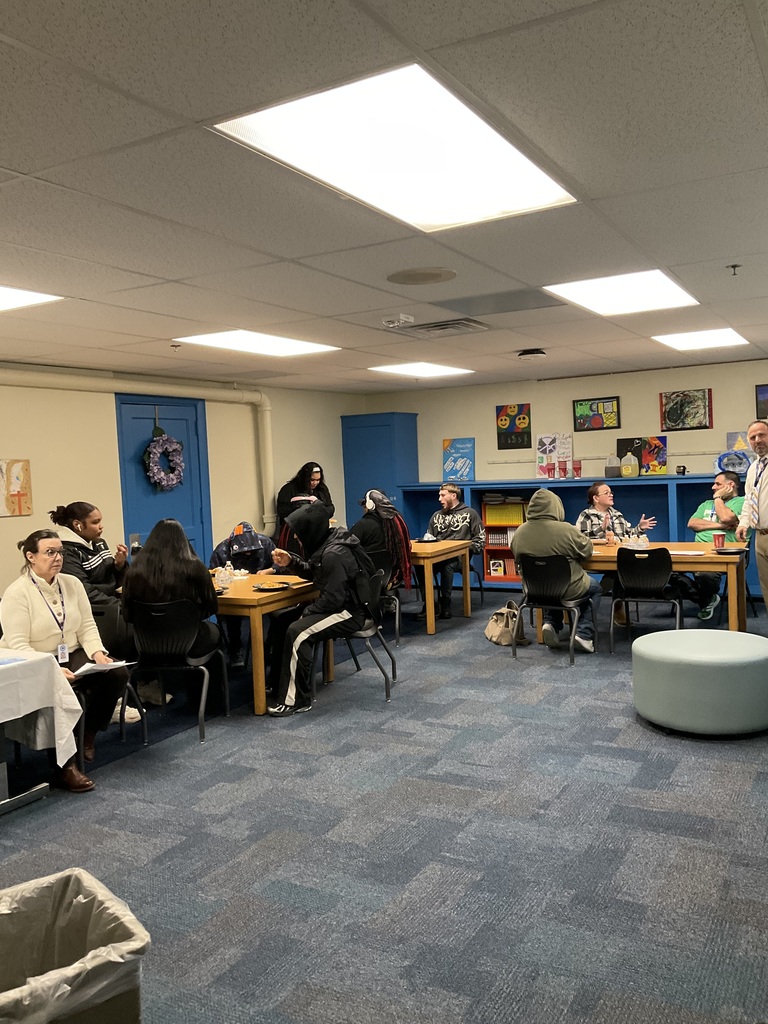 Students and teachers are gathered together sitting talking