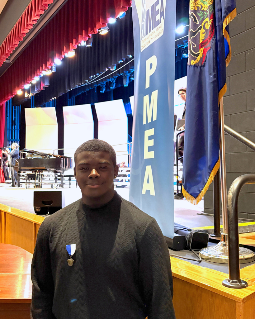 Eddie standing in front of PMEA banner on a stage.