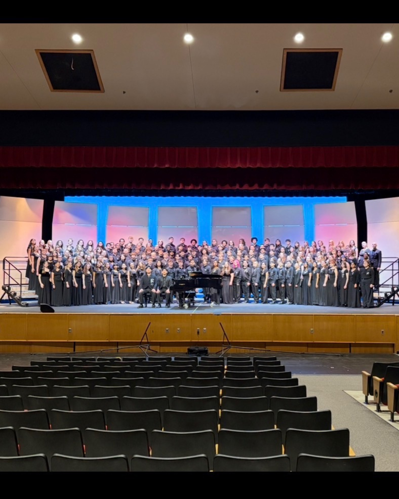PMEA Choir poses for large group photo on stage.