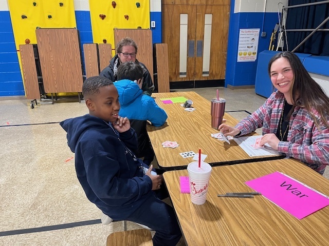 A teacher and student playing WAR at math night