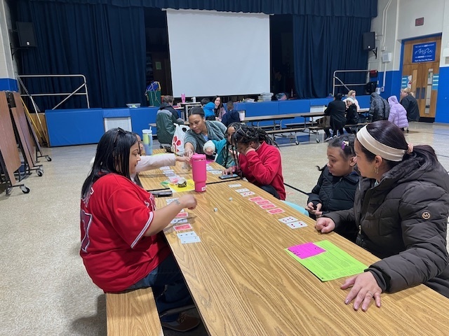 A teacher and a family playing a math card game
