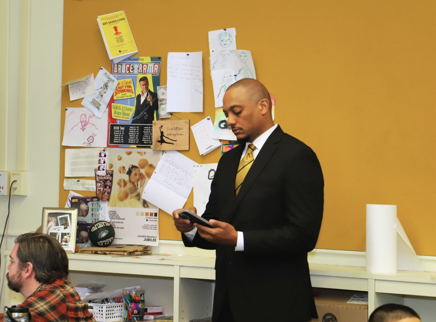 Alpha Phi Alpha members speak to students in a classroom.
