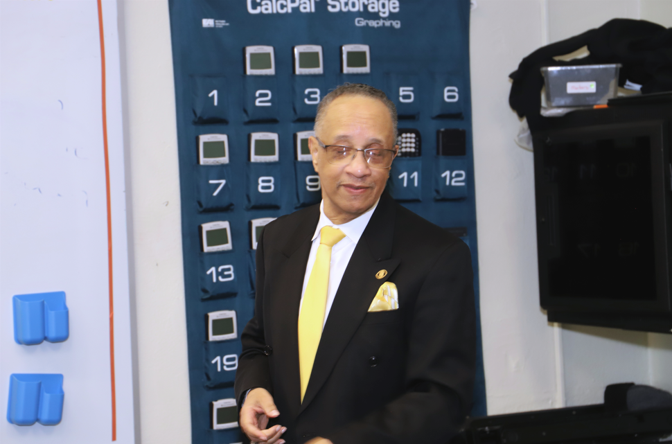 Alpha Phi Alpha members speak to students in a classroom.