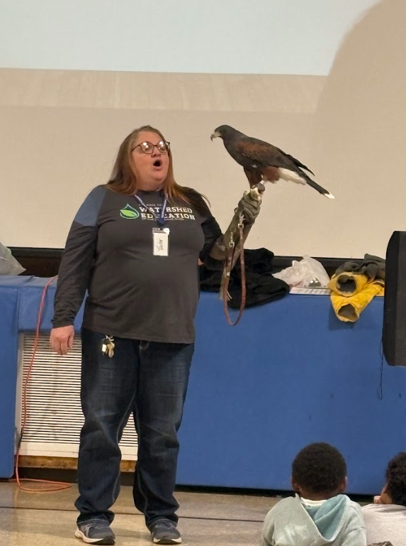 A speaker talking to first grade students about their upcoming trip