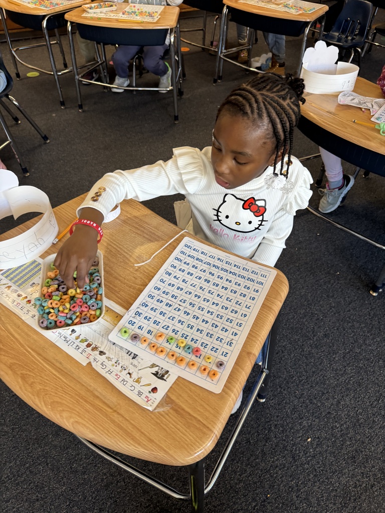 A first grader sorts 100 pieces of cereal into ten groups of ten.