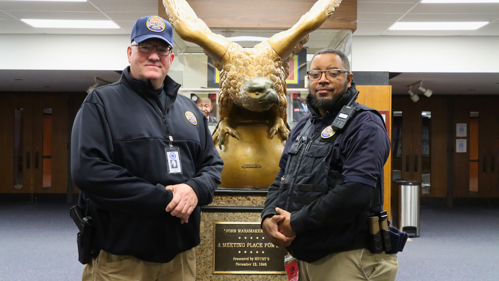 Two Guards from NAHS pose for photo in front of the Eagle statue in the NAHS lobby.