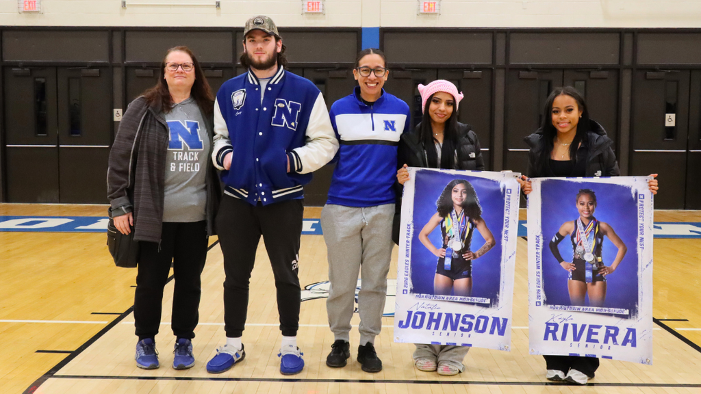 Indoor track seniors pose for photo with coaches.