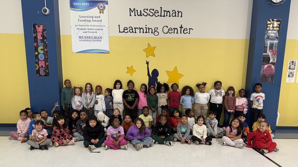 students in front of Musselman learning sign