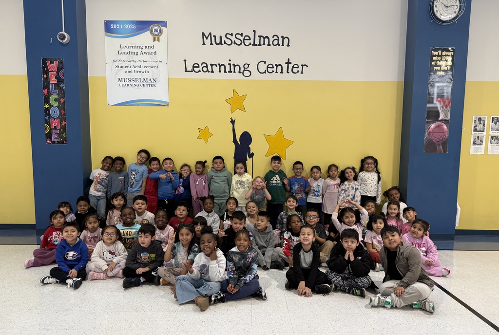 students in front of Musselman learning sign
