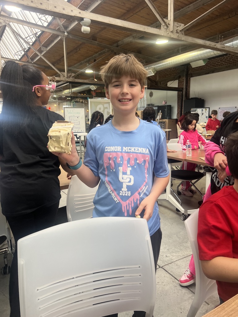 A third grader shows his science project at Flux Space.