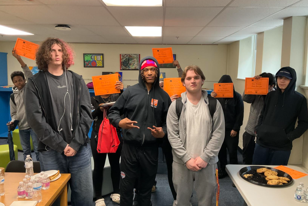 A group of students are holding their awards together for a picture.