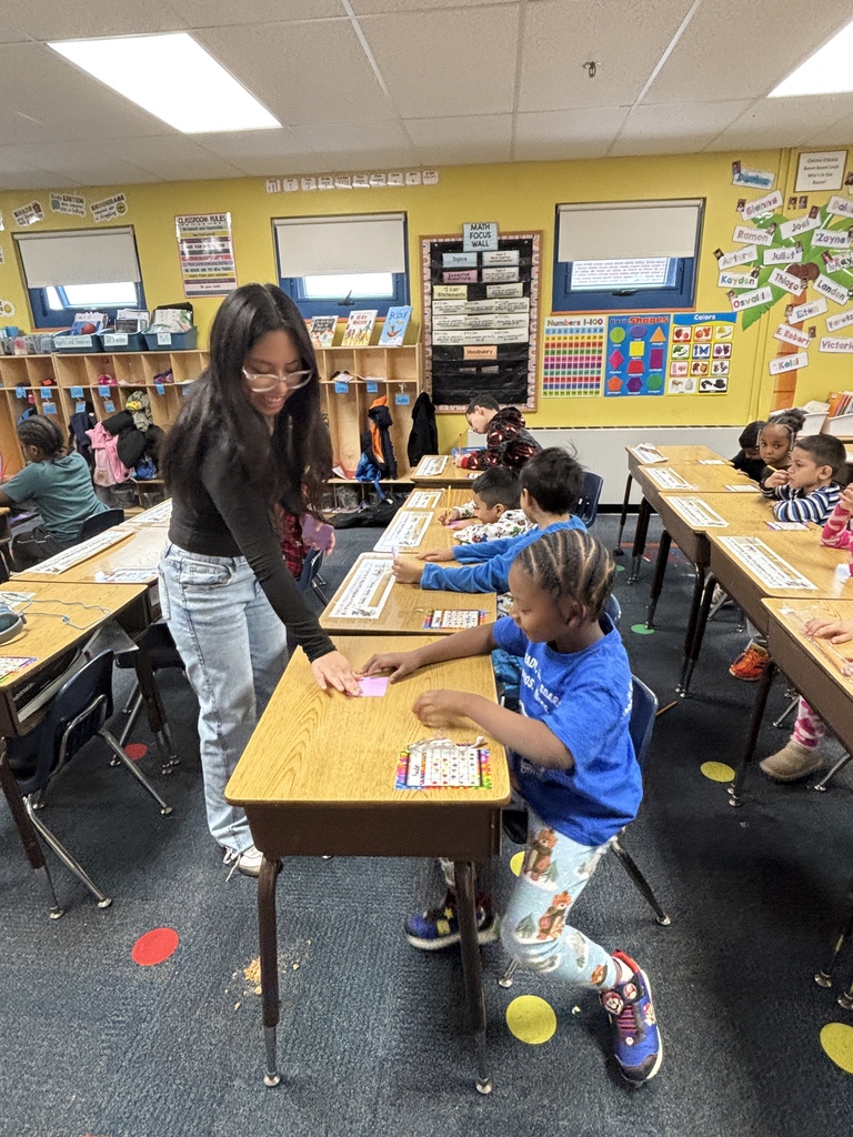 students writing words at their desk on a piece of paper