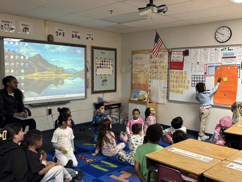 students placing a post it note on the whiteboard