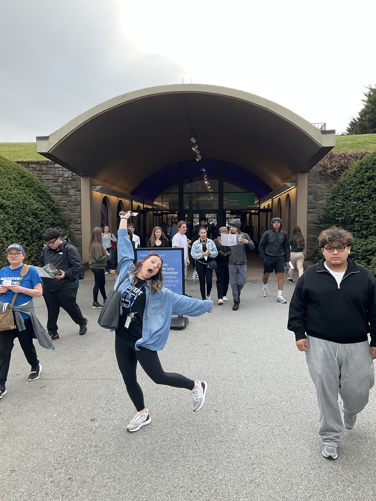 Students and teachers are posing as they are walking into longwood gardens