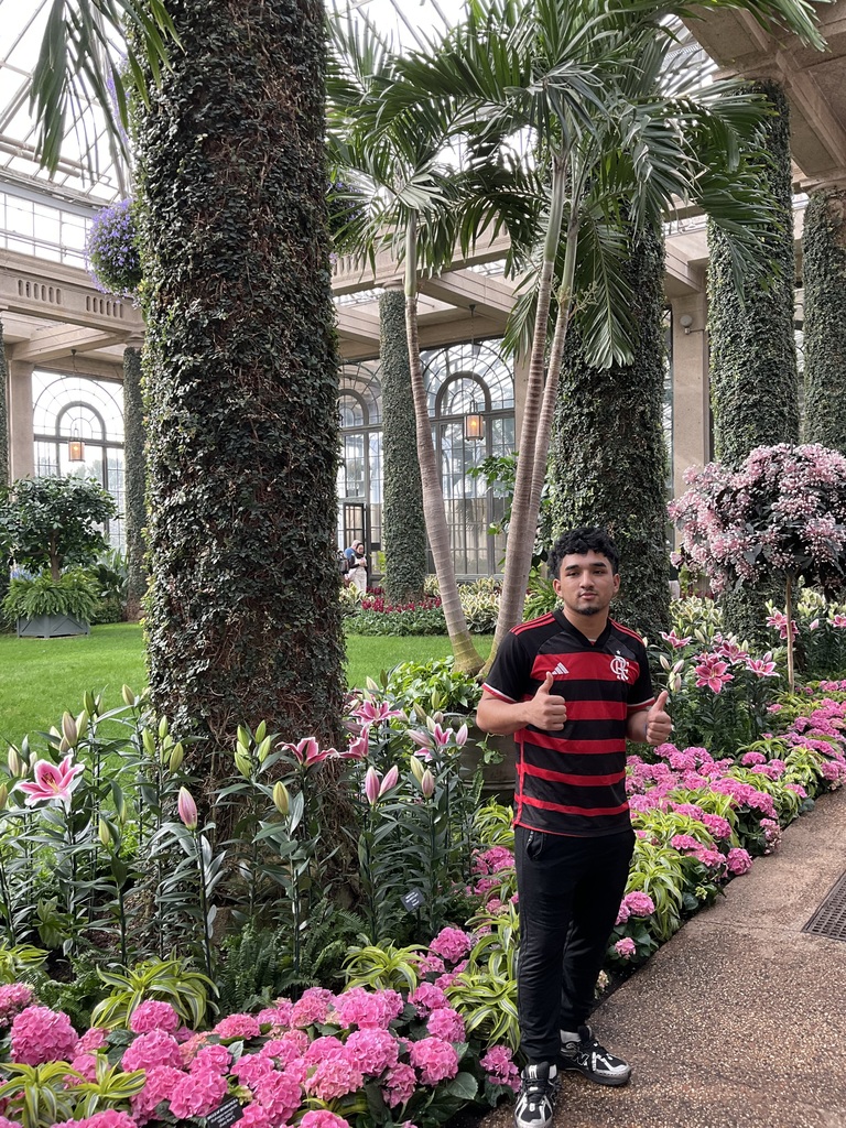 A student is posing next to flowers