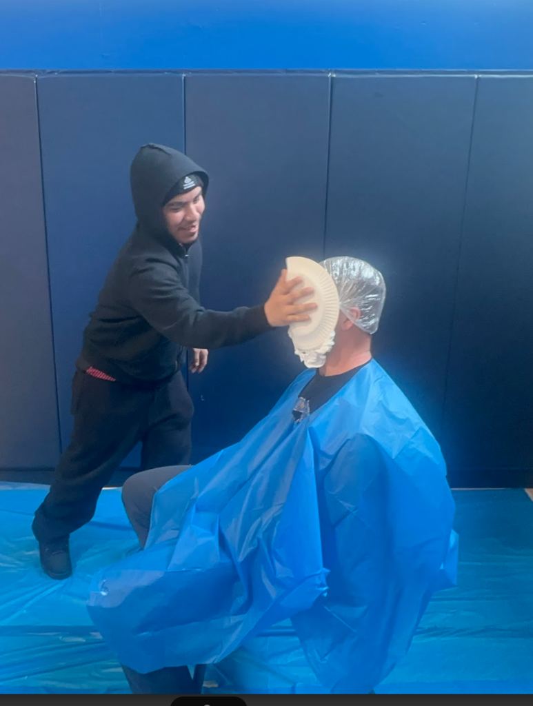 A student is pieing a teacher in the face