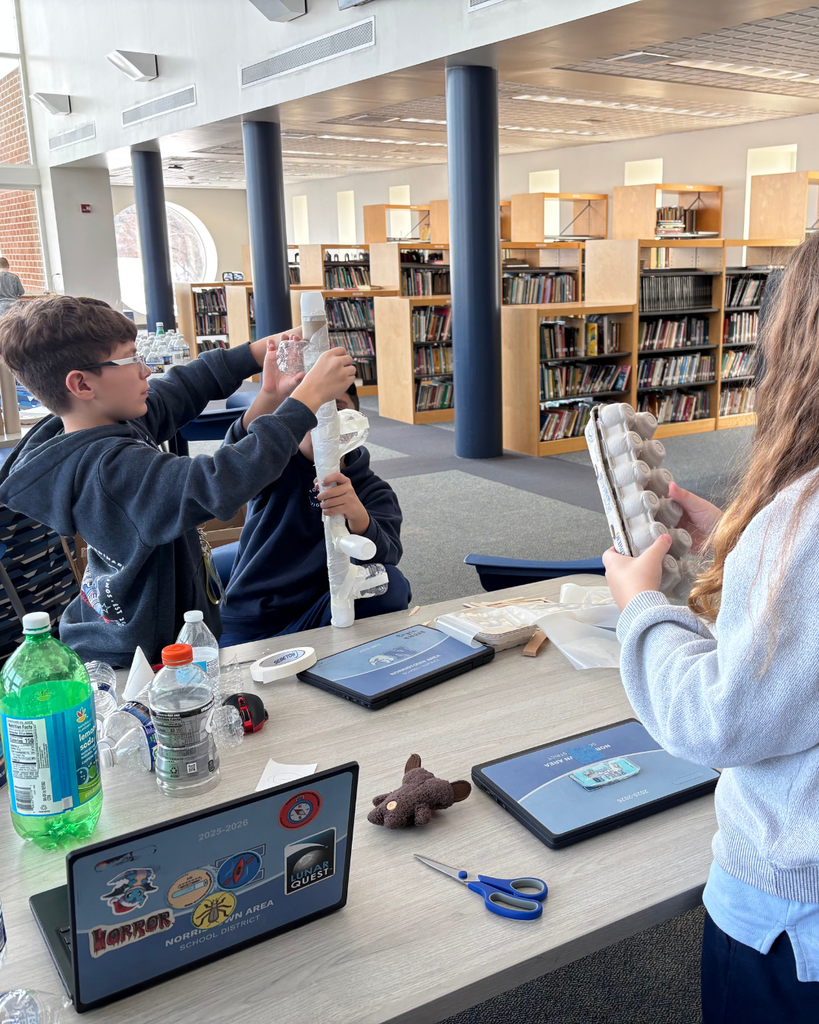 Group of 3 studnets working on their Dream It, Design It project with cardboard.