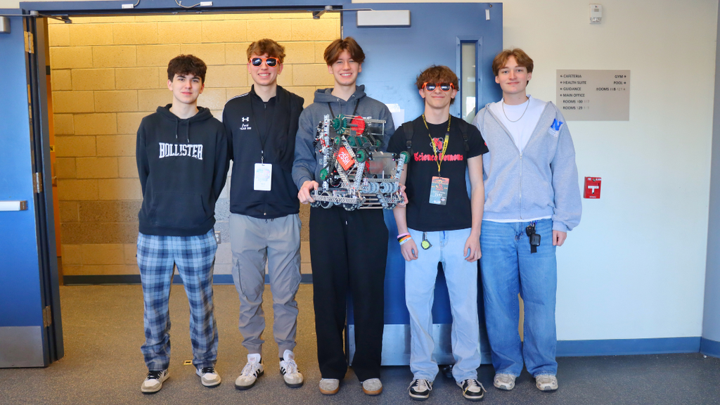 NAHS Robotics team posees for a photo with their robot. 