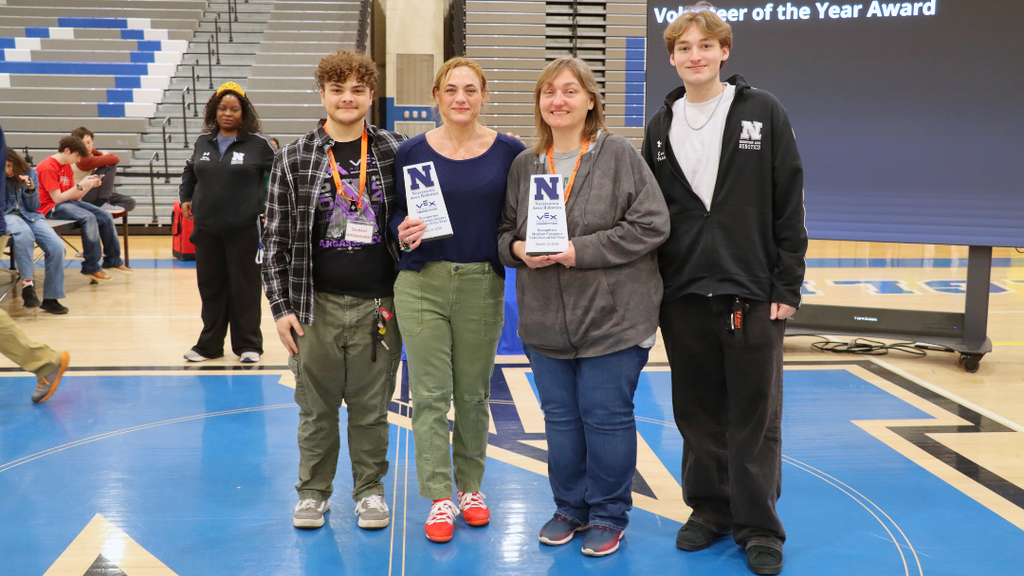 Two Volunteer of the Year Award recipients pose with their trophies and studnets.  
