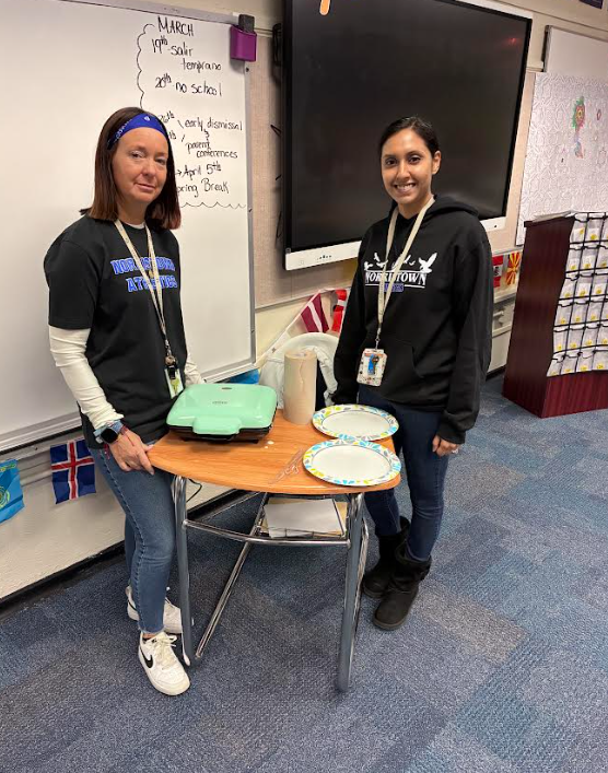 Two teachers are standing with their waffle maker