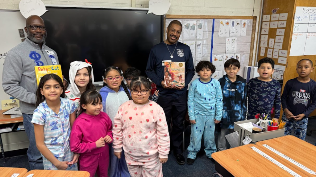 Group of students and guest readers pose for a photo. 
