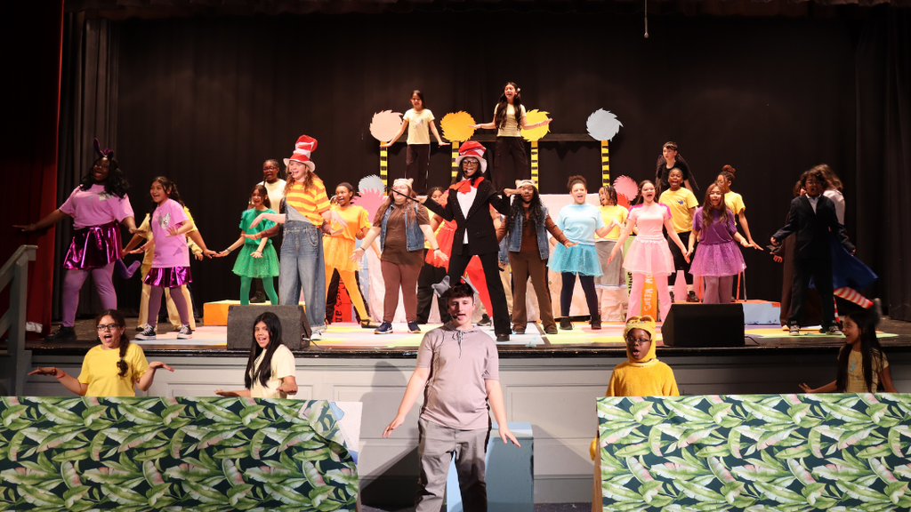 Middle school students performing for their spring musical on stage.