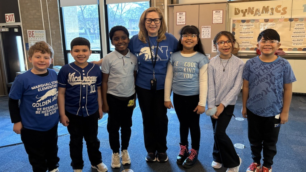 Group of studnets and teacher pose for photo. 