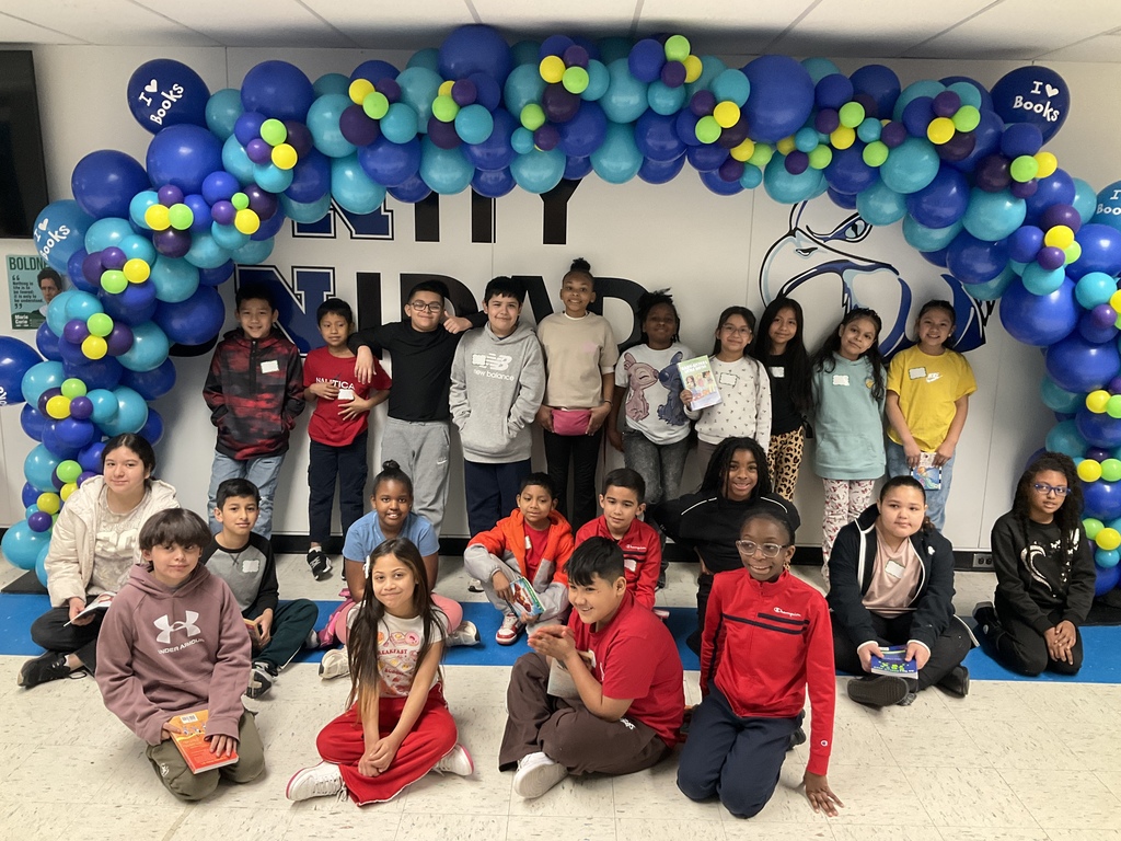 A class waiting to get their books from the book giveaway