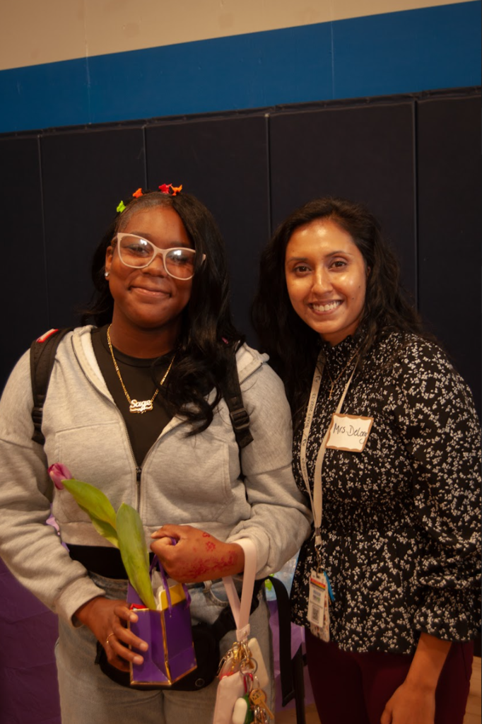 A student and a teacher are smiling together