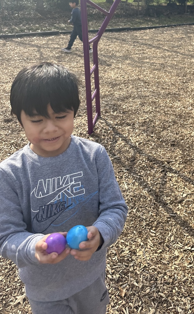 Kindergarteners participate in an egg hunt on the playground.