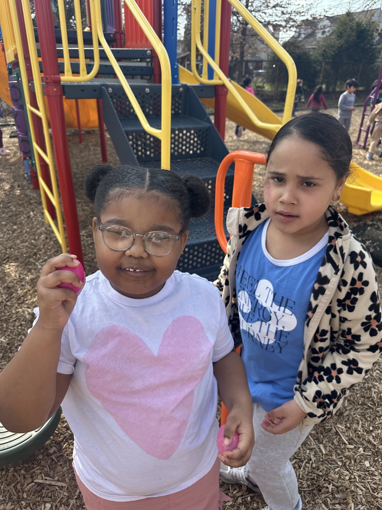 Kindergarteners participate in an egg hunt on the playground.