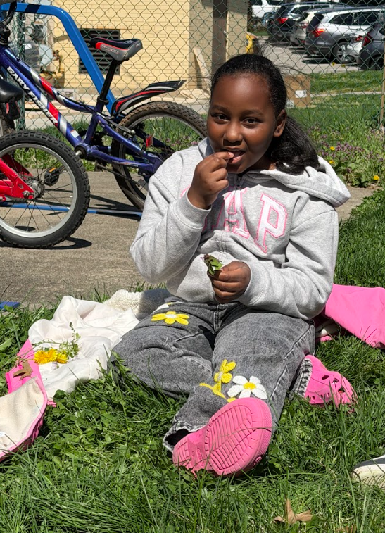 A student sitting outside in the grass