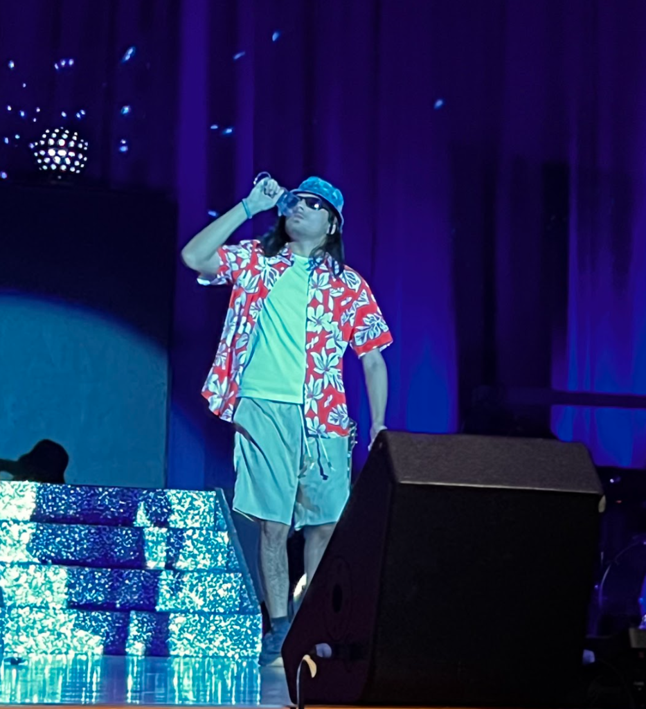 Male student is walking on the stage in his aloha shirt for the casual wear