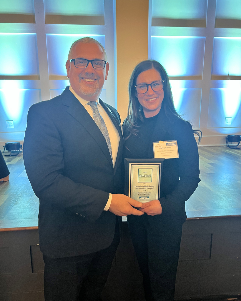 NASD Superintendent and Ostroff Godshall executive director pose for photo with award plaque.