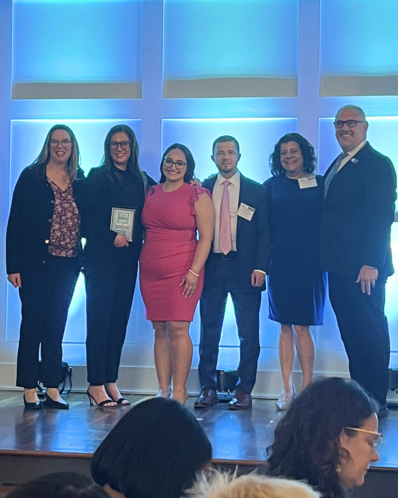 NASD and Ostroff Godshall teams accepting award on stage.