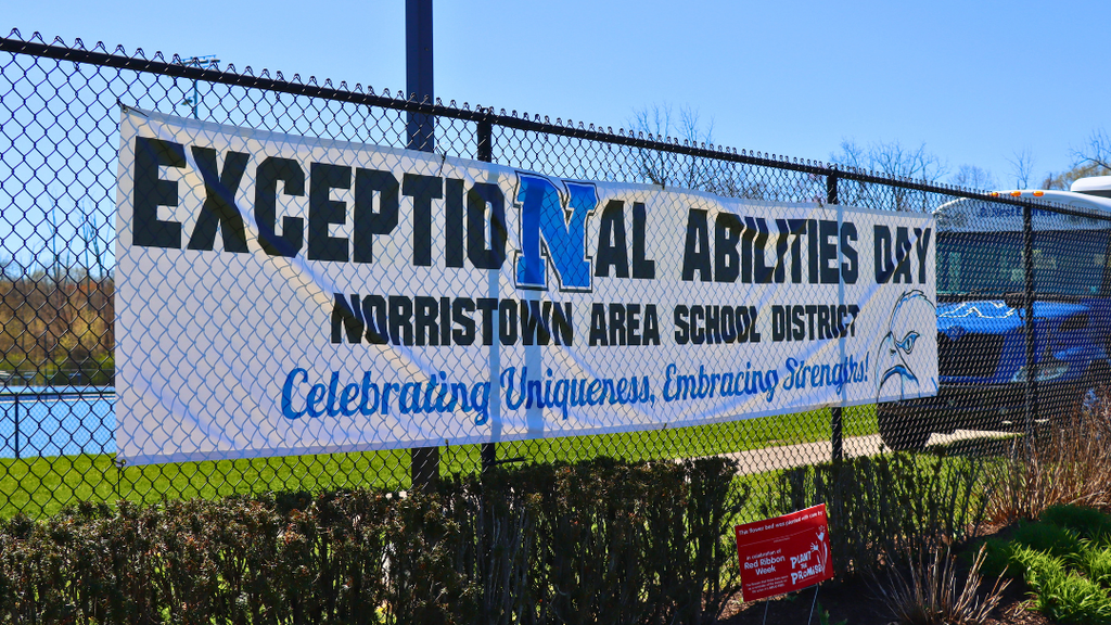 Exceptional Abilities Day banner hanging on the fence at the entrance of the athletic complex. 