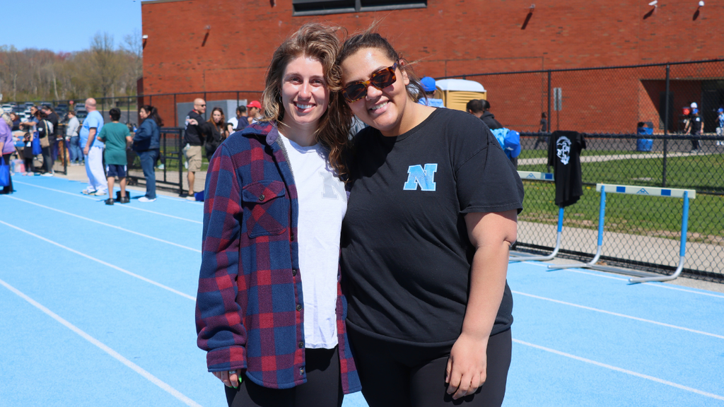 Two staff members pose for photo on the track during exceptional abilities day. 