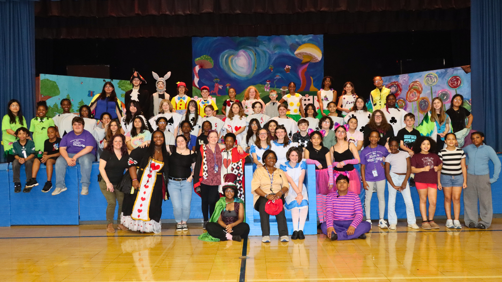 Cast and crew of ENMA Drama Club pose for large group photo on and in front of the stage. 
