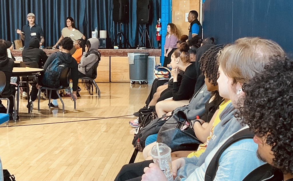 Students are listening to the presenters in the gym