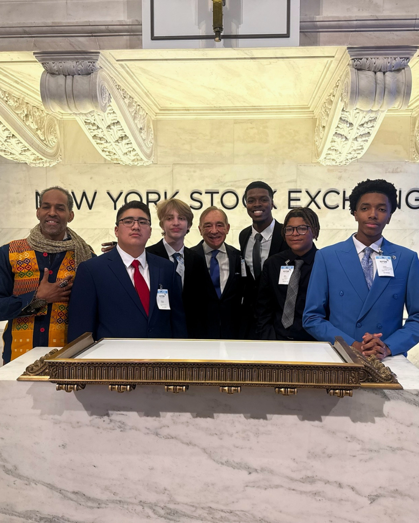 Students pose in front of New York Stock Exchange. 